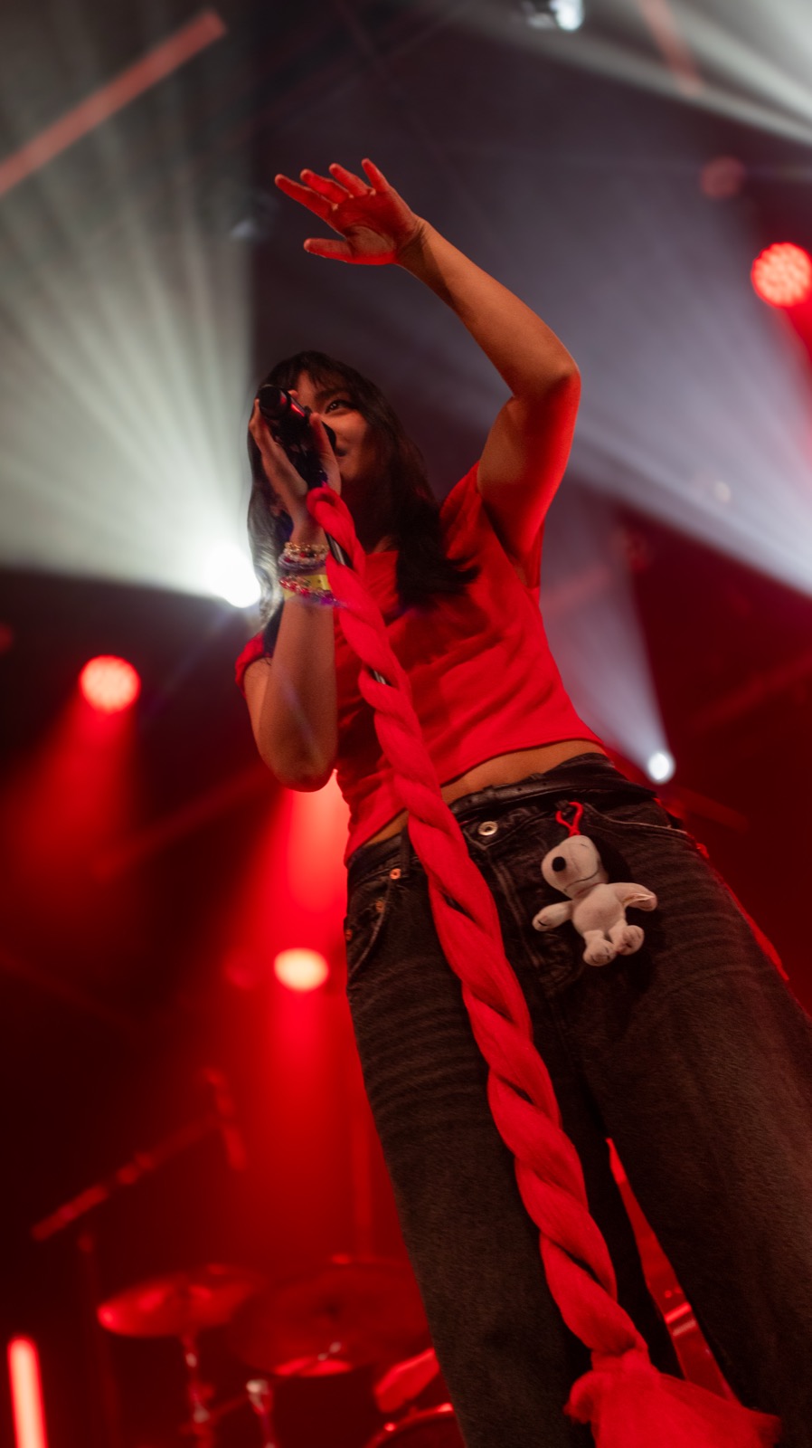 Vocalist reaching toward the crowd in red light